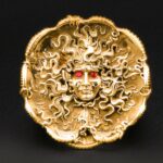 Golden Medusa head with red eyes.