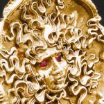 Golden Medusa sculpture with red gemstone eyes.
