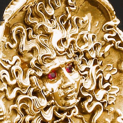 Golden Medusa sculpture with red gemstone eyes.