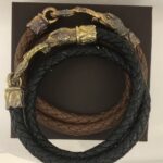 Braided leather bracelets with ornate metal clasps.